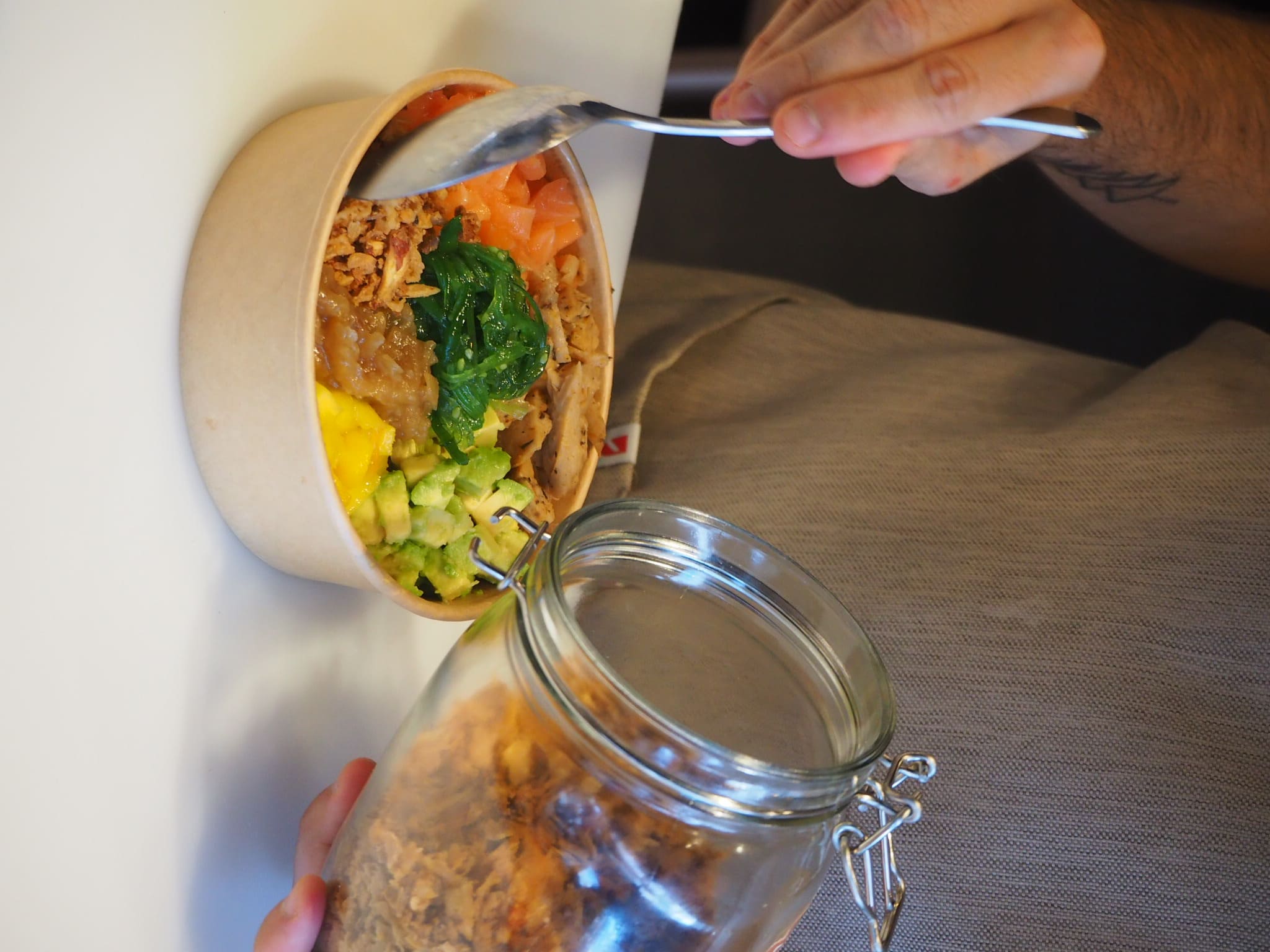 Chef de Kea Healthy for vertiendo ingredientes secos sobre un bowl personalizado de comida saludable